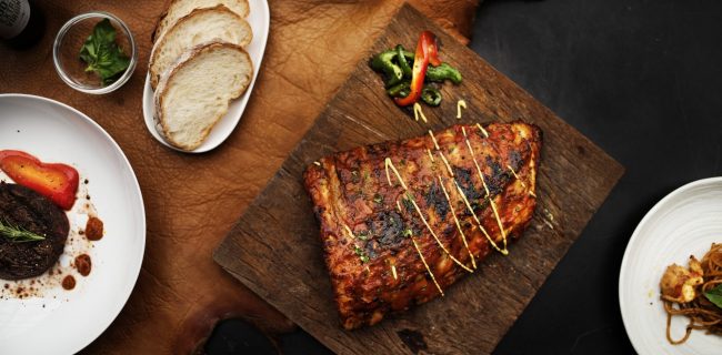 Closeup of pork ribs steak on wooden board food styling